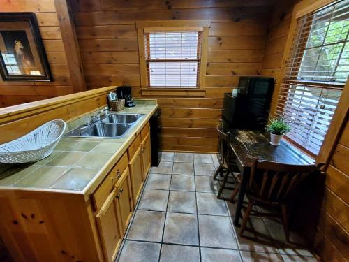 a kitchen with a sink and a table in a cabin at Charming Riverside Cabin Sanctuary Near New River, Virginia in Galax