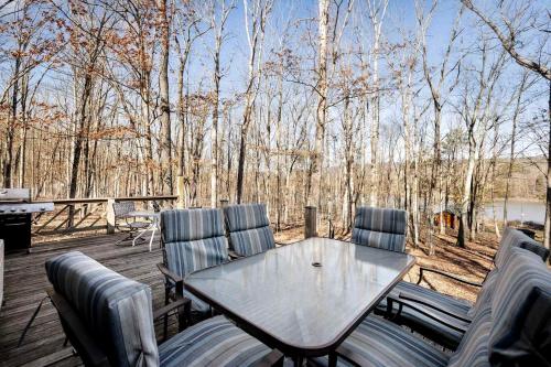 a patio with a table and chairs on a deck at Lustrous Lakefront Cabin Oasis near Lake Ferndale in West Virginia in Springfield