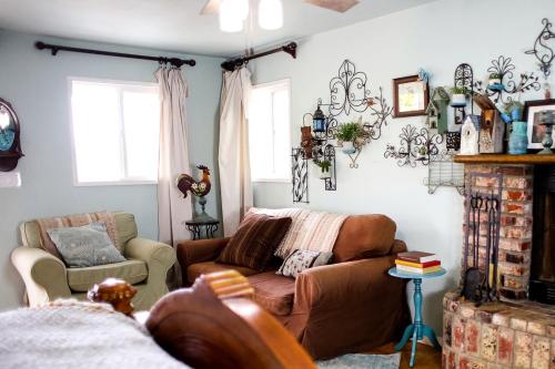 un salon avec un canapé et une chaise dans l'établissement Pet Friendly Breathtaking Cottage with Hot-tub in Rainbow, California, à Rainbow