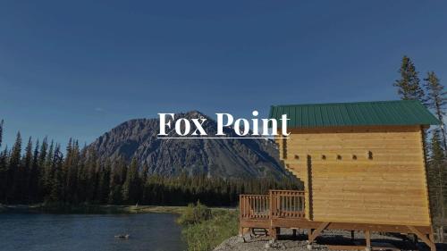 a wooden cabin next to a lake and a mountain at Remote and Serene Lakefront Cabin in Cantwell, Alaska, with Gorgeous Views of Nations Mountain in Cantwell