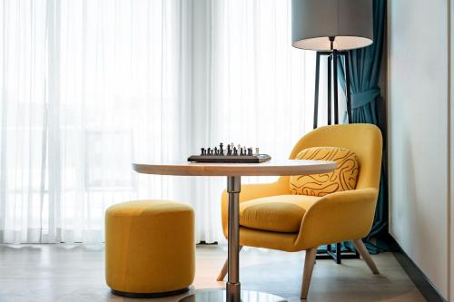 a table and a chair with a chess board on it at M Social Hotel Phuket in Patong Beach