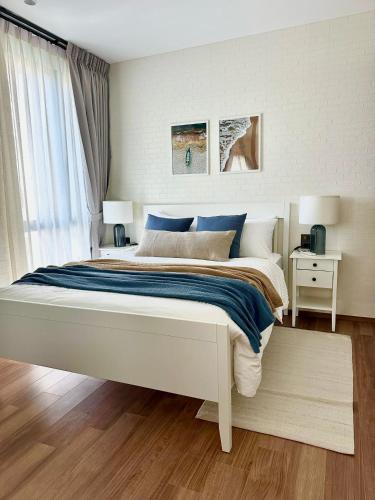 a bedroom with a large white bed with blue sheets at Title Halo Andaman Coast Pool View Gym in Nai Yang Beach