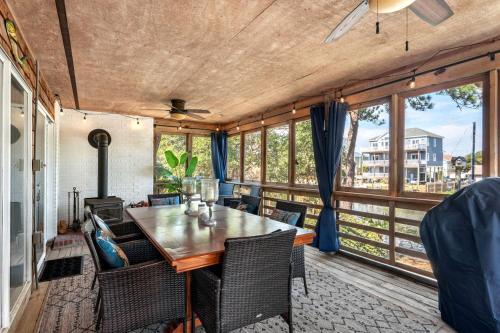 a dining room with a table and chairs and windows at Gorgeous Waterfront Vacation Rental for an Unforgettable Family Getaway in Frisco, North Carolina in Frisco
