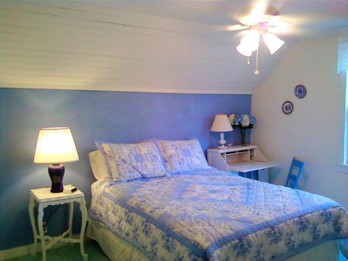 a bedroom with a bed with a blue wall at Historic Vacation Rental on Acres of Farmland near Aloha State Park, Michigan in Alverno