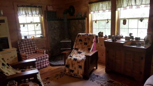 a kitchen with a chair in a room with windows at Cute Finger Lakes Cabin Rental for a Relaxing New York Getaway in Prattsburg