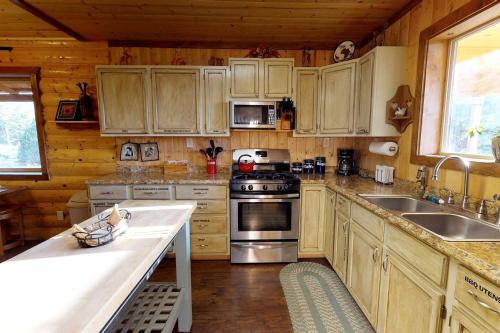 a kitchen with wooden cabinets and stainless steel appliances at Western Town Retreat in Monticello, Utah in Verdure