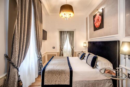 a hotel room with a bed and a chandelier at The Britannia Hotel in Rome