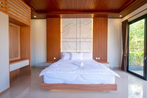 a bedroom with a large bed with a large window at Tutde Guest House in Bringkit