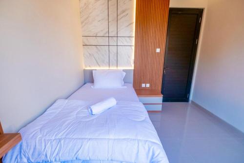 a bed with a white pillow on top of it at Tutde Guest House in Bringkit