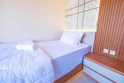two beds in a small room with white sheets at Tutde Guest House in Bringkit