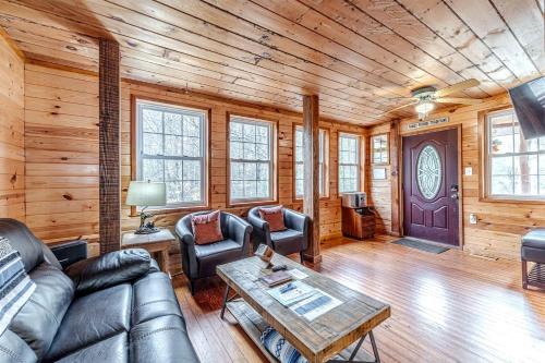 a living room with leather furniture and wooden walls at Serene Cabin with Hot-Tub in Cleveland, Georgia in Kinseytown
