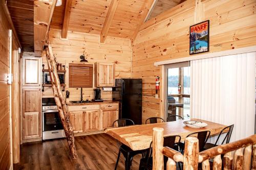 DeersvilleにあるLuminous Cabin with Hot-Tub, BBQ and Deck in Ohioのテーブルと冷蔵庫のあるダイニングルーム