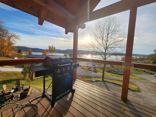 DeersvilleにあるLuminous Cabin with Hot-Tub, BBQ and Deck in Ohioの水辺の景色を望むデッキのグリル