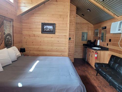 a bedroom with a bed and a couch in a room at Lovely Log Cabin Rental for Four near San Antonio Texas in Pipe Creek