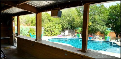 a view of a swimming pool from the porch of a house at Lovely Log Cabin Rental for Four near San Antonio Texas in Pipe Creek