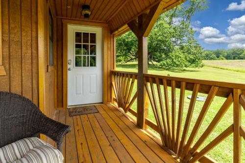 a porch of a wooden house with a white door at Serene Loft Cabin with Outdoor Grill and Fire Pit in Creal Springs, Illinois in Sunset Harbor