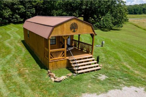 a gazebo with a staircase in the grass at Serene Loft Cabin with Outdoor Grill and Fire Pit in Creal Springs, Illinois in Sunset Harbor