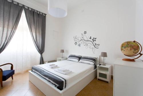 ein weißes Schlafzimmer mit einem Bett und einem Fenster in der Unterkunft Caselita in Palermo