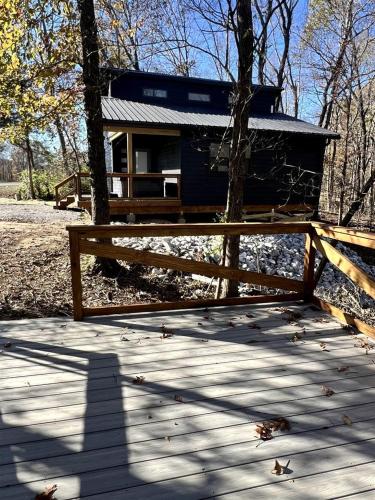 a small cabin with a fence on a wooden deck at Cozy Rustic Cabin with Hot-Tub Ideal for a Couples Retreat in Illinois in Etherton