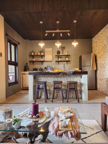a kitchen with a table and a counter with stools at Prana Siargao Resort in General Luna