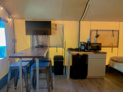 a small kitchen with a table and chairs in a tent at Impressive Safari Tent with Barbecue in Staples, Texas in Staples