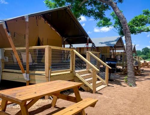 a wooden playground with a bench and a house at Impressive Safari Tent with Barbecue in Staples, Texas in Staples