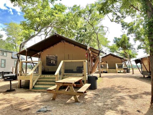 a tent with a picnic table and a bench at Impressive Safari Tent with Barbecue in Staples, Texas in Staples