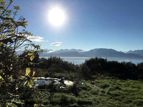 a view of a body of water with the sun in the sky at Luxury Camping Tent Overlooking Kachemak Bay in Homer, Alaska in Fritz Creek