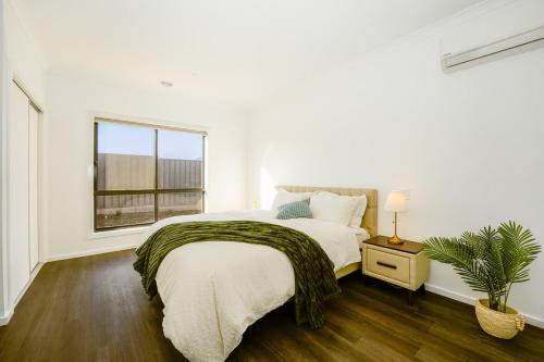 a white bedroom with a large bed and a window at 3 Bedroom 3 Bath Accessible Bathrooms in Melton South