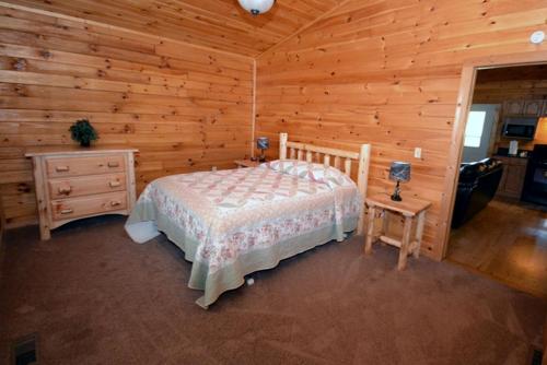 a bedroom with a bed in a log cabin at Cozy Log Cabin near Hocking Hills State Park, Ohio in Cedar Grove