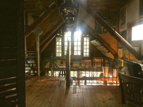 an attic room with a large window and wooden floors at Eclectic Riverfront Log Cabin and Artist Retreat for Groups in Castle Hayne, North Carolina in Castle Hayne