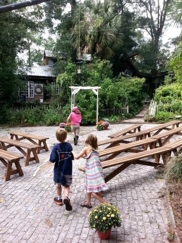 two children are shaking hands in front of benches at Eclectic Riverfront Log Cabin and Artist Retreat for Groups in Castle Hayne, North Carolina in Castle Hayne