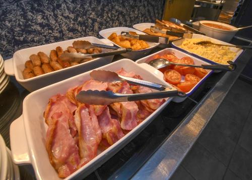 a buffet with several trays of different types of food at The Queens Hotel & Victoria Cloisters Apartments in York