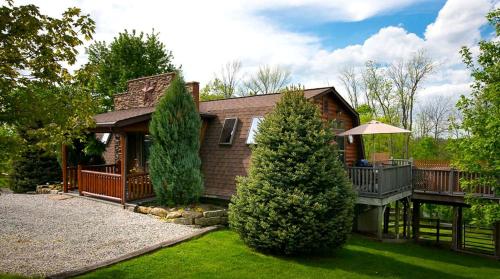 a house with a porch and a deck at Romantic Forest Cabin with Amazing Private Deck and Spa in Ohio in Walnut Creek