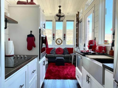 a kitchen with a red rug and a couch at Guardian Angel Tiny House near Zion National Park in Virgin