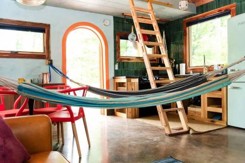 a hammock in a room with chairs and a ladder at Charming Pet-Friendly Cabin with Stunning Mountain Views in Chattanooga, Tennessee in Whitwell