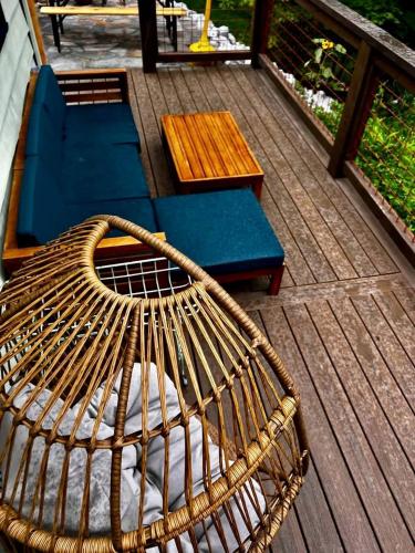 a rattan bench and a blue couch on a deck at Charming Pet-Friendly Cabin with Stunning Mountain Views in Chattanooga, Tennessee in Whitwell