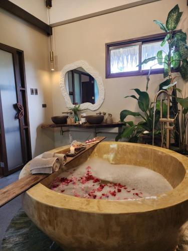 a large wooden bath tub in a room with a mirror at Prana Siargao Resort in General Luna