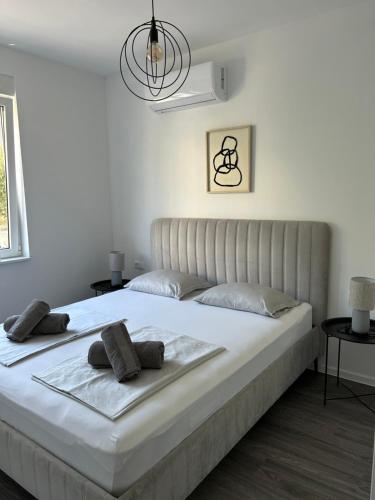 a bedroom with a large white bed with two pillows at Apartman Buba in Jesenice