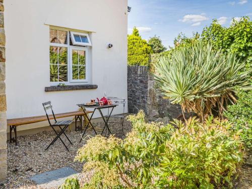 a garden with a table and chairs in front of a house at 2 Bed in Llangattock BN228 in Llangattock