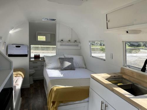a small room with a bed and a kitchen at Rustic Charm meets Modern Luxury: Cozy Airstream in Grand Junction, Colorado in Grand Junction