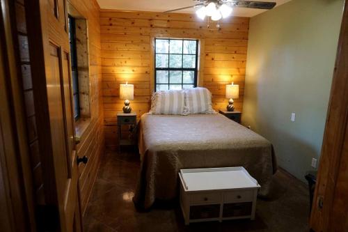 a bedroom with a bed in a room with a window at Spacious Log Cabin Rental for Family Vacations in Texas in Nacogdoches