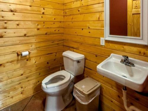 a wooden bathroom with a toilet and a sink at Spacious Log Cabin Rental for Family Vacations in Texas in Nacogdoches