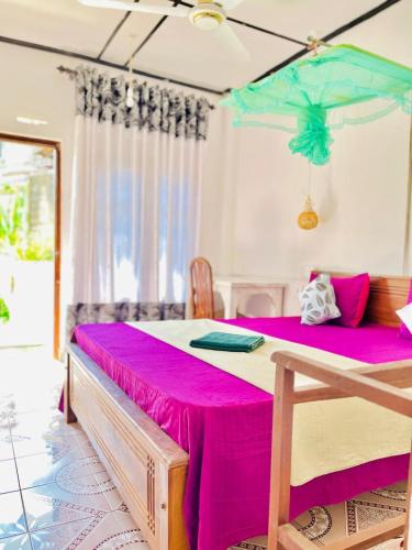 a bedroom with a pink table with a blue umbrella at Nethu Freedom Cottage in Weligama