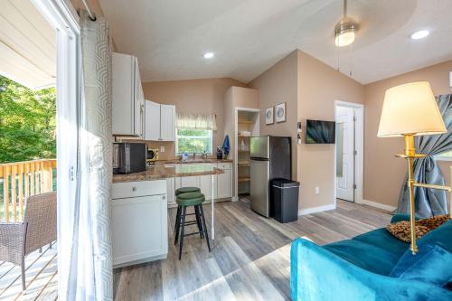 a living room with a blue couch and a kitchen at Off-Grid Tiny House with Fire Pit and Countryside Views in Tennessee in Parrottsville