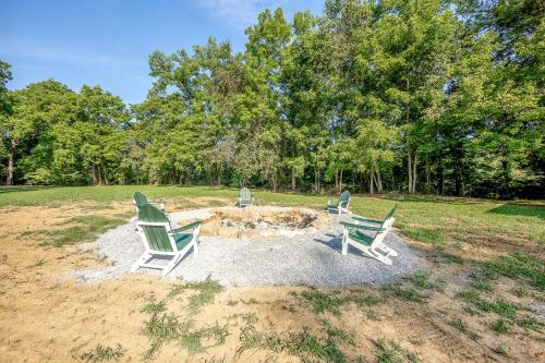 three lawn chairs sitting around a fire pit in a field at Off-Grid Tiny House with Fire Pit and Countryside Views in Tennessee in Parrottsville