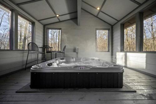 une baignoire jacuzzi dans une chambre avec fenêtres dans l'établissement Stunning Cabin with Games Perfect for Families in Broken Bow, Oklahoma, à Stephens Gap