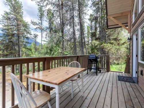 um deck de madeira com uma mesa e cadeiras em Family-Friendly Cabin Rental with Mountain Vistas near West Glacier, Montana em West Glacier