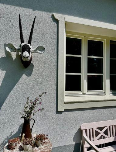 a wall with a window and a table with flowers at Grafit vendégház in Nagyrákos