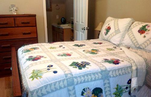 a bed with a quilt on it in a bedroom at Simple and Cozy Cabin Rental on Private Ranch Retreat near Austin, Texas in Waelder